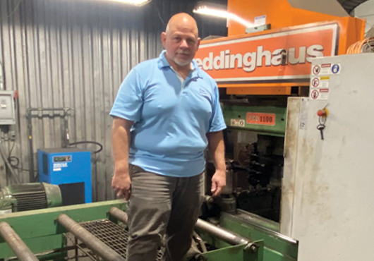 Henry Marfe, Owner and President of Mark & Son Metal Products, Inc., stands in front of the new Peddinghaus PCD-1100, which helps the company produce structural steel faster and more accurately.