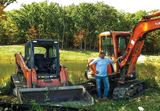 Jason Guelig, Owner and Operator of Jason Guelig Excavating, LLC, pictured here with a skid-loader and mini-excavator, part of his extensive fleet of machines.