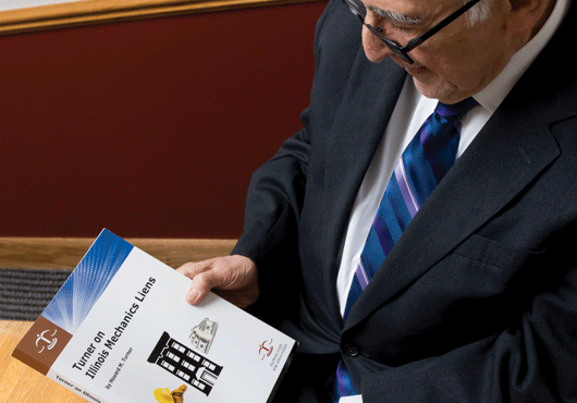 Howard Turner holding “Turner on Illinois Mechanics Liens,” the book he authored that is now considered the authoritative work on Illinois mechanics lien law. 