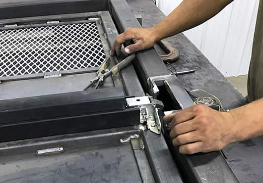 Shop Foreman Robert Bruno making the final adjustments to a new gate’s latch before the powder coat is applied.