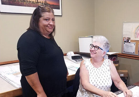 The mother-daughter team of Karen O’Connor (seated) and Terri O’Connor-Havard review the day’s work for their woman-owned business, Superior Floor Covering, Inc.