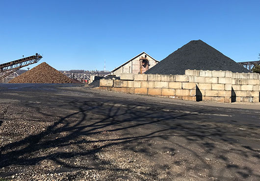In the early days, the yard of Cincinnati Bulk Terminals LLC, pictured here, was used to stockpile coal. Today, the yard is used to store limestone aggregate and other materials the company provides.