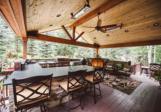 This Archadeck outdoor living vignette in Morrison, Colorado, includes an outdoor kitchen and corner fireplace with stone finish by Alberto Arrellano of AlStone Exceptional Masonry.