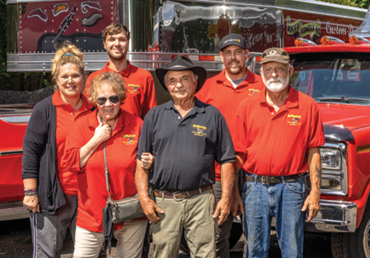 Rocco Iadarola (front center) and his wife, Joanne, the company’s Office Manager, are flanked by members of the Rocco Iadarola General Contracting Company team, including (from left) Assistant Office Manager Vanessa Jones  and Paving Specialists Jacob Jones, Jason Evon and Leonard Dorosh.