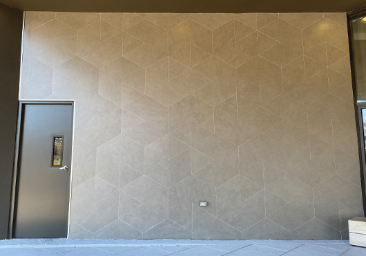 To install a tile mural on the exterior of Crowne Plaza White Plains New York (now Sonesta White Plains Downtown), National Retail Construction Group built a wooden barricade around the tile to help the grout dry during the cold weather installation.