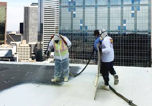 Crew members at work on the roof of a high-rise building in downtown Dallas.