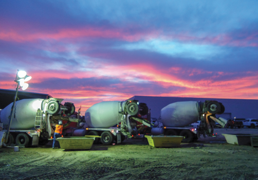 Ready-mix trucks empty washout water into receptacles under the California sunset before Cleanout Bin retrieves the contaminated water, bound for the recycle center.