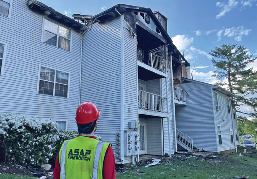 Fire Guard Antonio Fernandez surveys damage of a fire in Ashburn, VA.