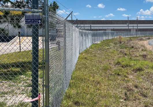 To protect some 1,800 feet of the property’s boundary, Straight Up Fence Inc. built a 7-foot-high chain-link fence with barbwire extensions around industrial park property used for storage by a roofing company in Orlando.
