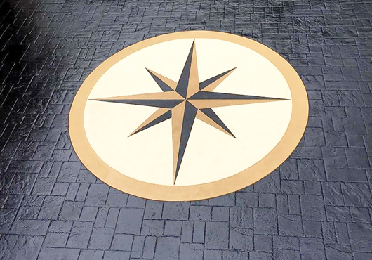 Hand-crafted compass rose set in an imprinted, slate-patterned concrete driveway at a residence in Holmdel Township, New Jersey.