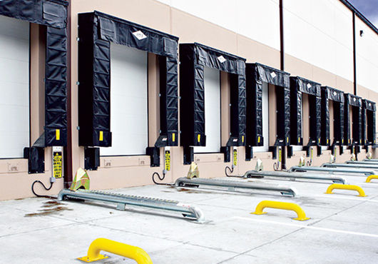 A row of newly installed dock shelters, sectional dock doors and Global Wheel-Lok vehicle restraints.