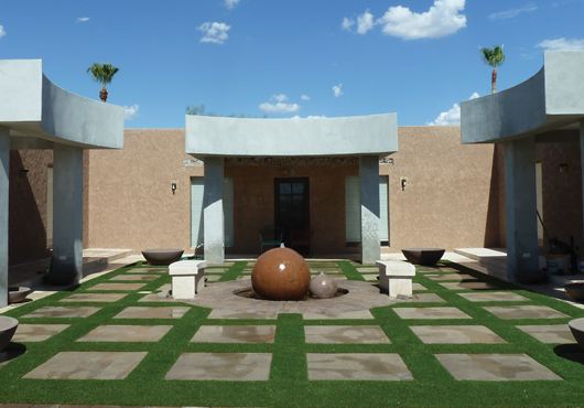 An intricate-cut design in the courtyard of a property in Desert Hills, Arizona, created with The Synthetic Grass Store LLC’s Daytona turf.