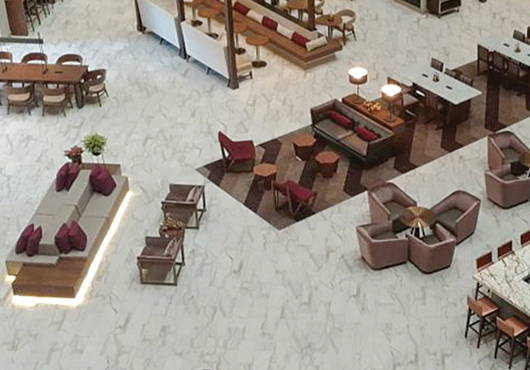 ABS Floor Covering has developed quality control programs that allow it to work on large-scale projects, including this tile with carpet insets at an Embassy Suites by Hilton Phoenix atrium.