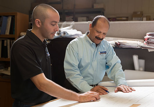 On the right is Michael Tarin, President, with his son, Garrett Tarin, Vice President, charting out a new system that uses technology based on a wireless GSM (Global Satellite Mobile) device that links to an alarm panel.