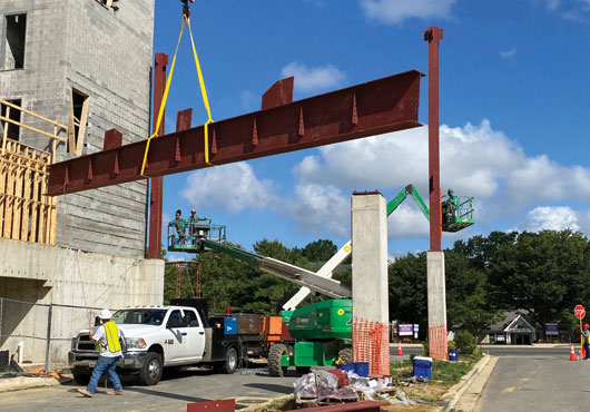 The first beam of the Largo, MD, bridge is placed as welder and installer Edwin Mendoza observes.