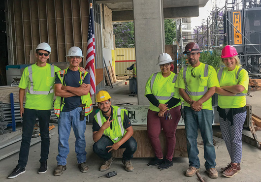 The team poses during the topping out of The Godfrey Hotel, a high-end boutique hotel in Hollywood, California.