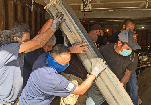 Velox Design and Construction employees (from left) Edgar Chinchilla, Hebert Oriana, Edy Chinchilla and Samuel Rodriguez install steel frames to the foundation of a Haight Street apartment building to protect from collapse during earthquakes.